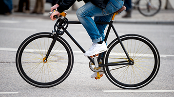 urban-biker-bikepage_JK_v1 Photo of a biker wearing jeans riding a bicycle.