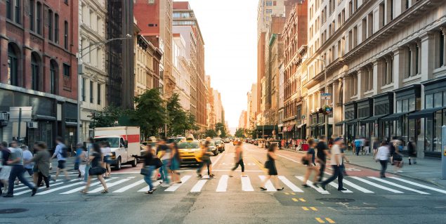 Crowds of people walking through a busy crosswalk at the intersection of 23rd Street and Fifth Avenue in Midtown Manhattan, New York City ""